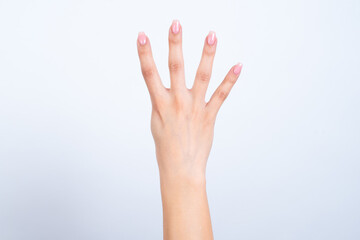 Woman's hand with pink manicure over isolated white background showing number four.