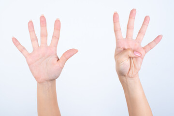 hands with pink manicure over white background pointing up with fingers number nine. 