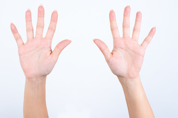 hands with pink manicure over white background pointing up with fingers number ten.