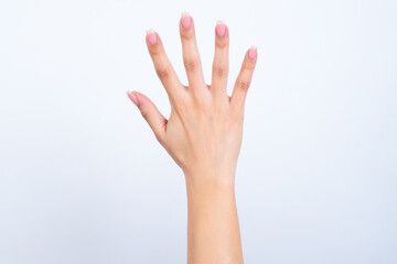 hands with pink manicure over white background showing with fingers number five. Back side of the hand.