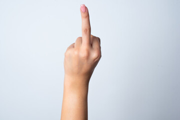 hand pointing up with middle finger, concept of rude hand sign or hand gesture, studio isolated over white background. 