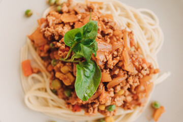 Homemade Spaghetti sauce with ground pork served in white dish.