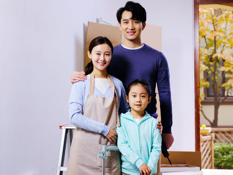 A happy family of three decorates their house