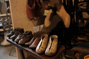 old workshop of a cobbler shoemaker with old shoes and patterns and work tools.