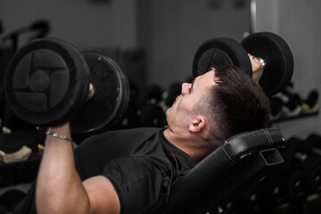 A sporty young man trains in the gym.Bodybuilding.