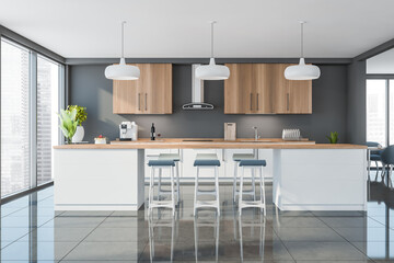 Wooden kitchen with white lower cabinets, table, blue bar stools.