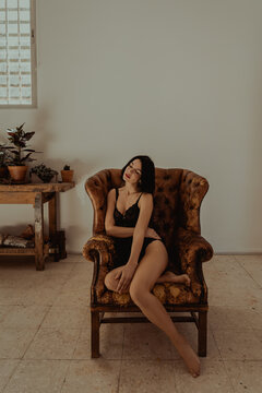 Calm woman resting in leather armchair