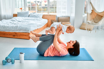 A sports mother is engaged with the child in fitness and yoga at home. The concept of sports,...