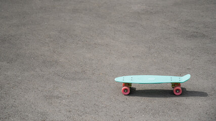 Blue penny board on the pavement. Copy space