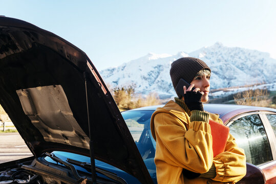 Woman having phone call after car breakdown