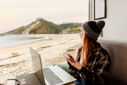 Traveling freelancer using smartphone and working in van