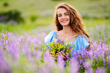 Fototapeta na wymiar Portrait of beautiful woman in amazing in a blooming field. Nature, vacation, relax and lifestyle. Summer landscape.
