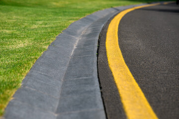 curve drainage channel cement hollow made of concrete on the side of an asphalt road with yellow...