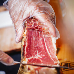 Professional Cutting Of Spanish ham, Jamon or Italian Prosciutto ham close-up, selective focus