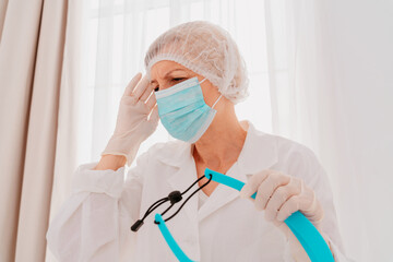 Fototapeta premium Doctor with face mask and face protector is tired about the covid-19 virus pandemic