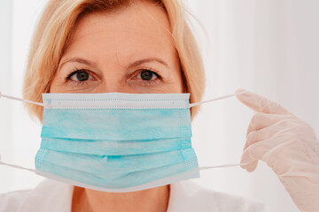 doctor adjust the face mask to protect herself against covid-19 virus