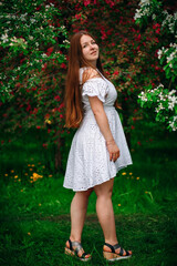 A happy girl in the park, in a white dress. Summer Park. Beautiful long hair.