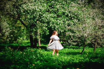 A happy girl in the park, in a white dress. Summer Park. Beautiful long hair.