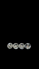 four swarovski beads. Diamond, crystal beads. Shining. Copy space. Black background. Vertical image. Wealth