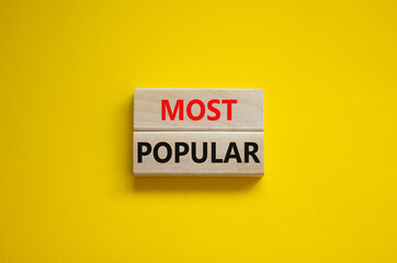 Most popular symbol. Concept words Most popular on wooden blocks on a beautiful yellow background. Copy space. Business and Most popular concept.