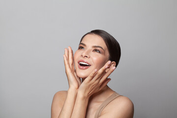 Beautiful excited surprised woman with open mouth, studio portrait on white background