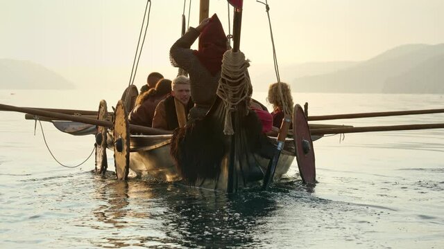 Medieval Ship with Vikings on Board Sails in the Middle of the River in a Magical Fog to new Shores. Concept of Romanticism.