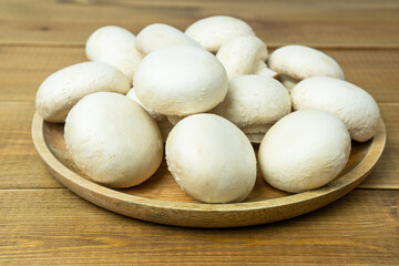 Fototapeta na wymiar Raw or fresh mushroom champignons on wooden table.