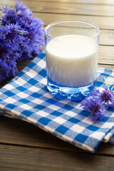 Jar of milk and cornflowers on a old brown wooden table