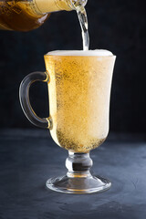Chilled light beer with foam in a glass mug. Pouring Beer Into A Glass At The Bar Or Pub Counter.