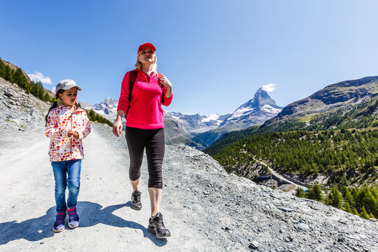 Hiking - hiker woman on trek with backpack living healthy active lifestyle. Hiker girl walking on hike in mountain nature landscape in Swiss alps, Switzerland.