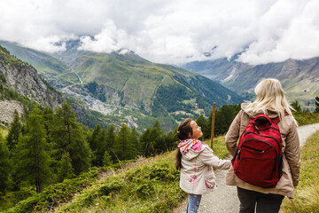 Naklejka premium Mother and to children going for a walk in mountain surroundings