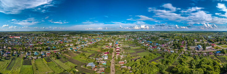 Obraz premium over the streets of the district center - the working village Tokarevka (Tamabov region, center of Russia) - a large aerial panorama on a sunny summer day