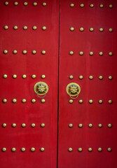 Red door with lion heads in asian style.
