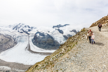 Mother and to children going for a walk in mountain surroundings
