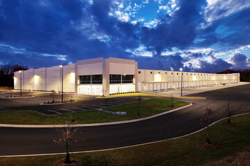 Exterior of white generic business warehouse industrial building at sunset