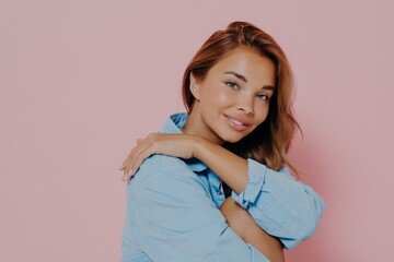 Charming lady with beautiful smile on pink background