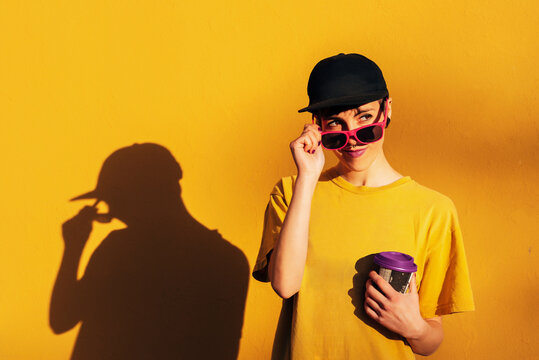 Modern woman drinking hot beverage and looking away