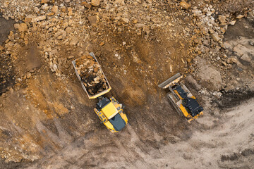 Heavy industrial excavator digs the ground and transfers it to the truck.