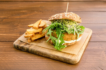 Vegan burger with battered falafel fillet, green arugula, bean sprouts and rustic bread with seeds...