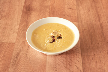 mild Indian curry, korma, yellow with dried fruits and dehydrated fruits with grated coconut inside a white bowl