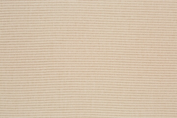 Texture of beige knitted sweater fabric.