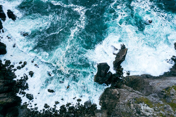 Aerial shot of waves from the Atlantic crashing on cliffs on the West Coast of Ireland 