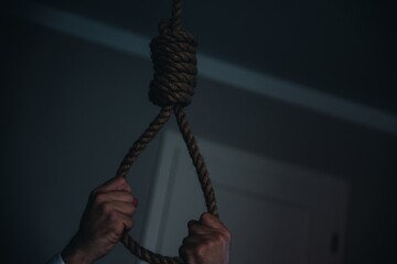 Men's hands hold rope loop. Concept of depression, hopelessness, and suicide.
