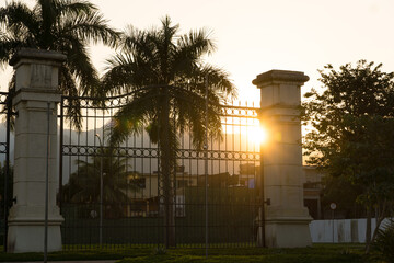 Fototapeta premium Beautiful sunset in Barra da Tijuca in Rio de Janeiro, Brazil. Hill, trees, and buildings. Against light.