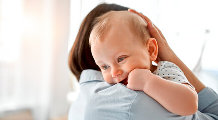 Loving mom carying of her newborn baby at home.Mom and baby boy playing in sunny bedroom. Parent...