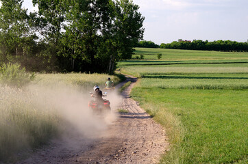 people ride quad bikes on dirt road summer outdoor activities © Viktoriia Kolosova