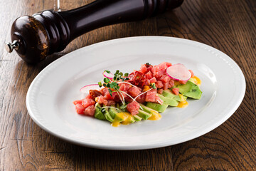 Tartar from fresh raw tuna with spices close-up on a plate