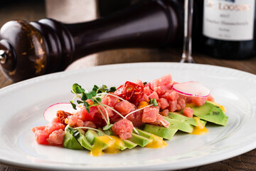 Tartar from fresh raw tuna with spices close-up on a plate