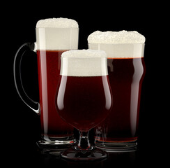 Set of fresh stout beer glasses with bubble froth isolated on black background.