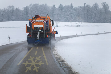 snow plow, winter service on a wet road, winter service truck driving on asphalt road at day while...